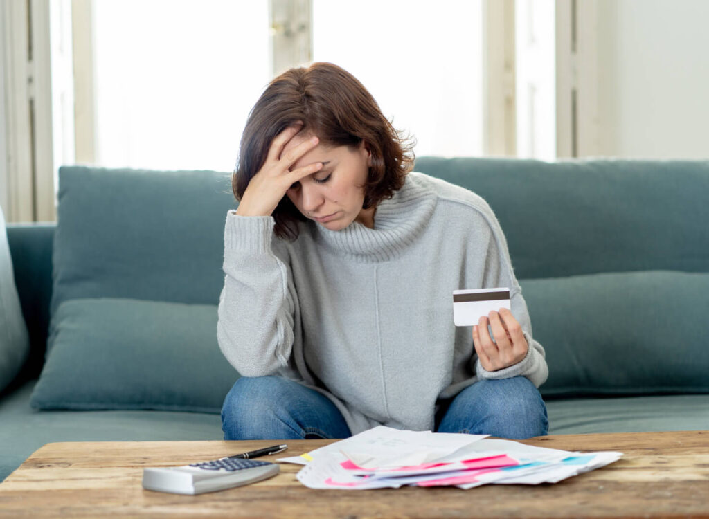 woman looking at bills thinking about the signs of financial stress